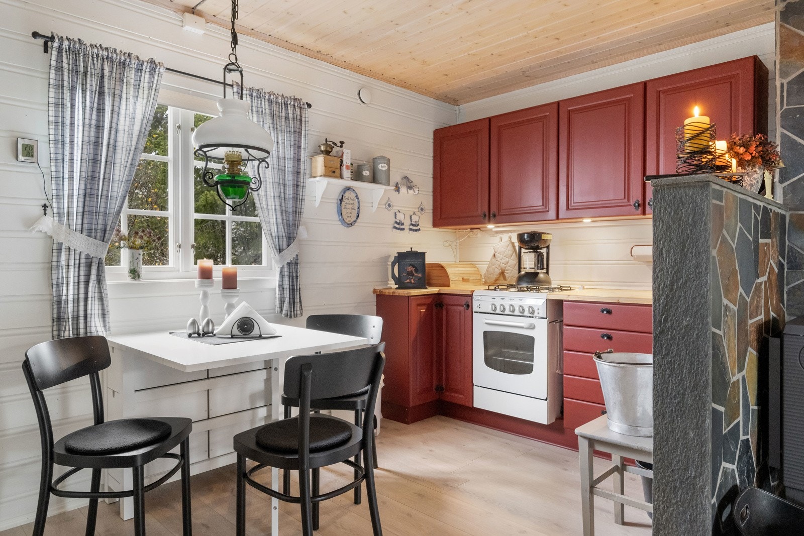 Kjøkken med spiseplass og gasskomfyr. Heltre, malt kjøkkeninnredning Galleribilde