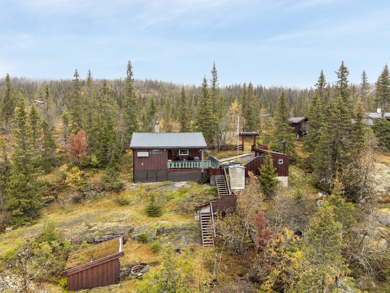 Hytta er delvis inngjerdet rundt ved platting, uthus og inngangsparti, slik at man slipper beitedyr. Galleribilde