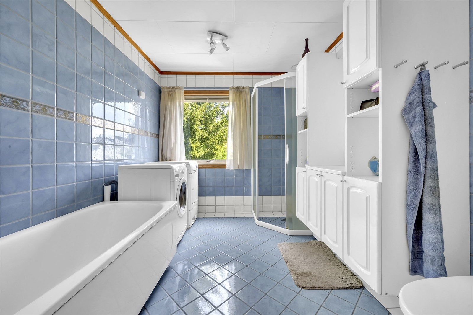 Baderom med fliser på gulv med gulvvarme, fliser på vegger og takplater i himling Galleribilde