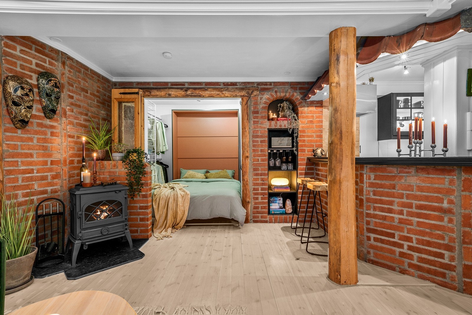 Det er også installert en lukket vedovn som gir både lun varme og ekstra hygge i stuen. I indre del av rommet er det etablert en fordelaktig alkove med plass for både seng og åpen garderobeløsning! Galleribilde