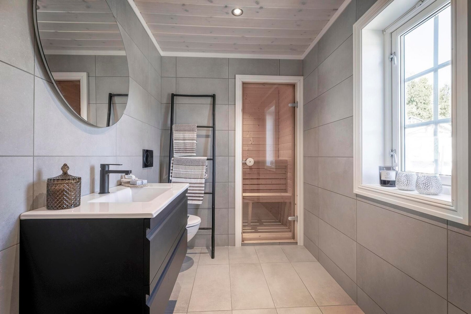 Lekkert bad med flislagte gulv og vegger. Her også med badstue i tilknytning til badet Galleribilde