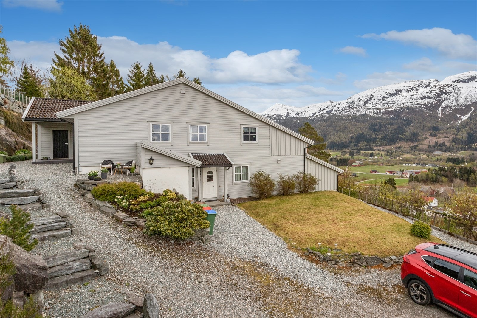 Pent opparbeidd uteområde med gangstiar og parkering på felles grusa tunområde. Galleribilde