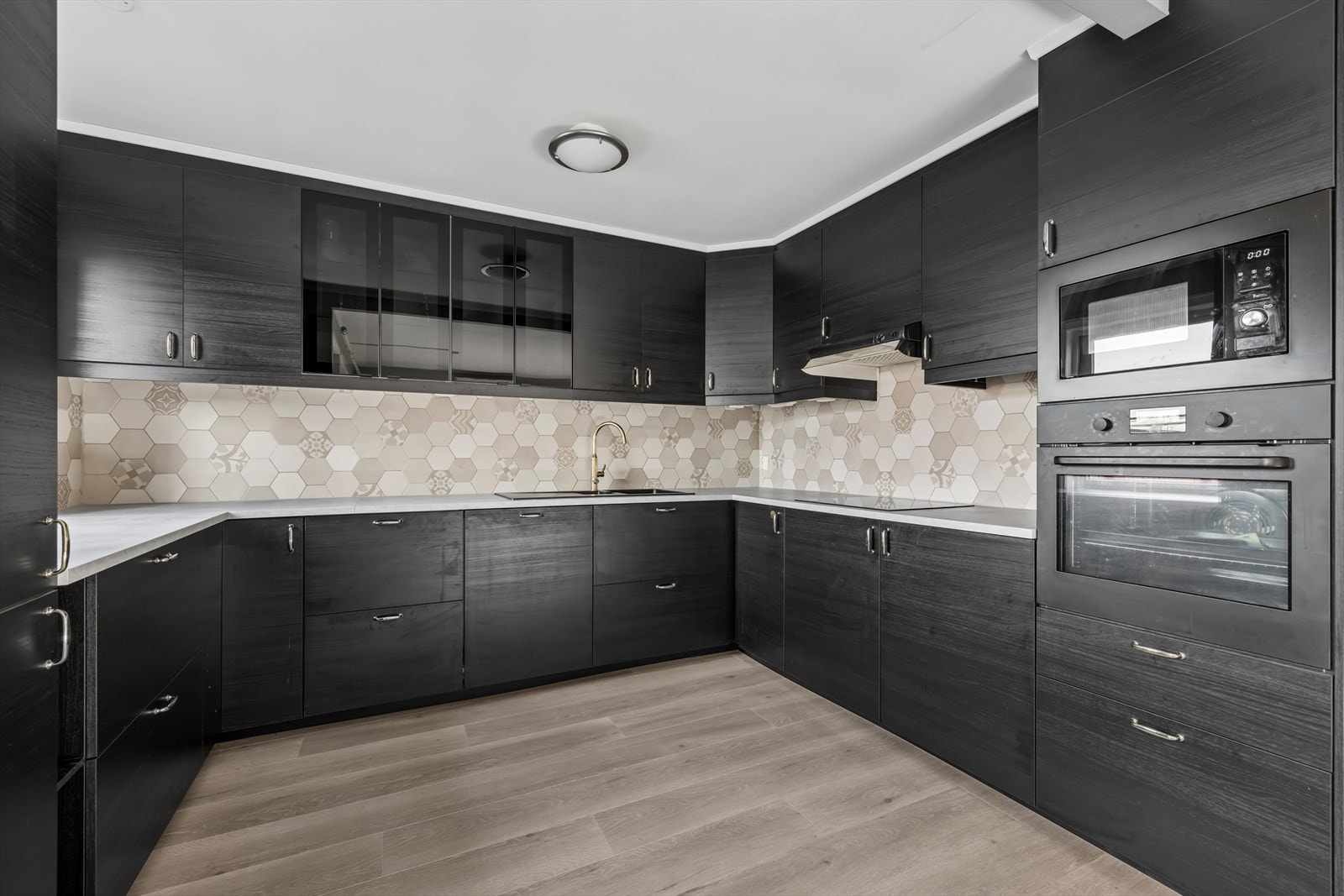 Velutstyrt og pent kjøkken med glatte fronter. Galleribilde