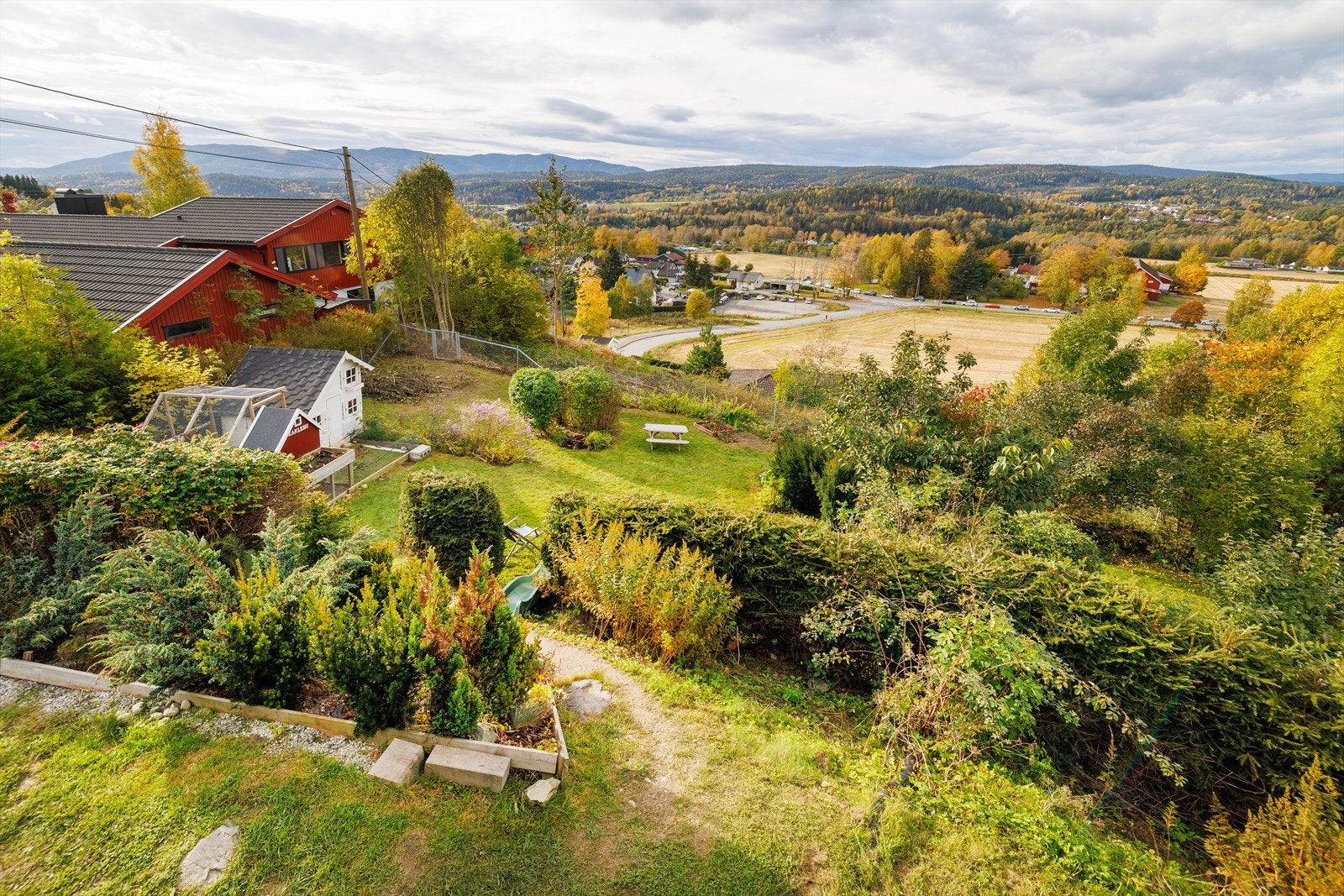 Tomten er pent opparbeidet med gressplen, diverse beplantning og en stor, gruset gårdsplass. Galleribilde
