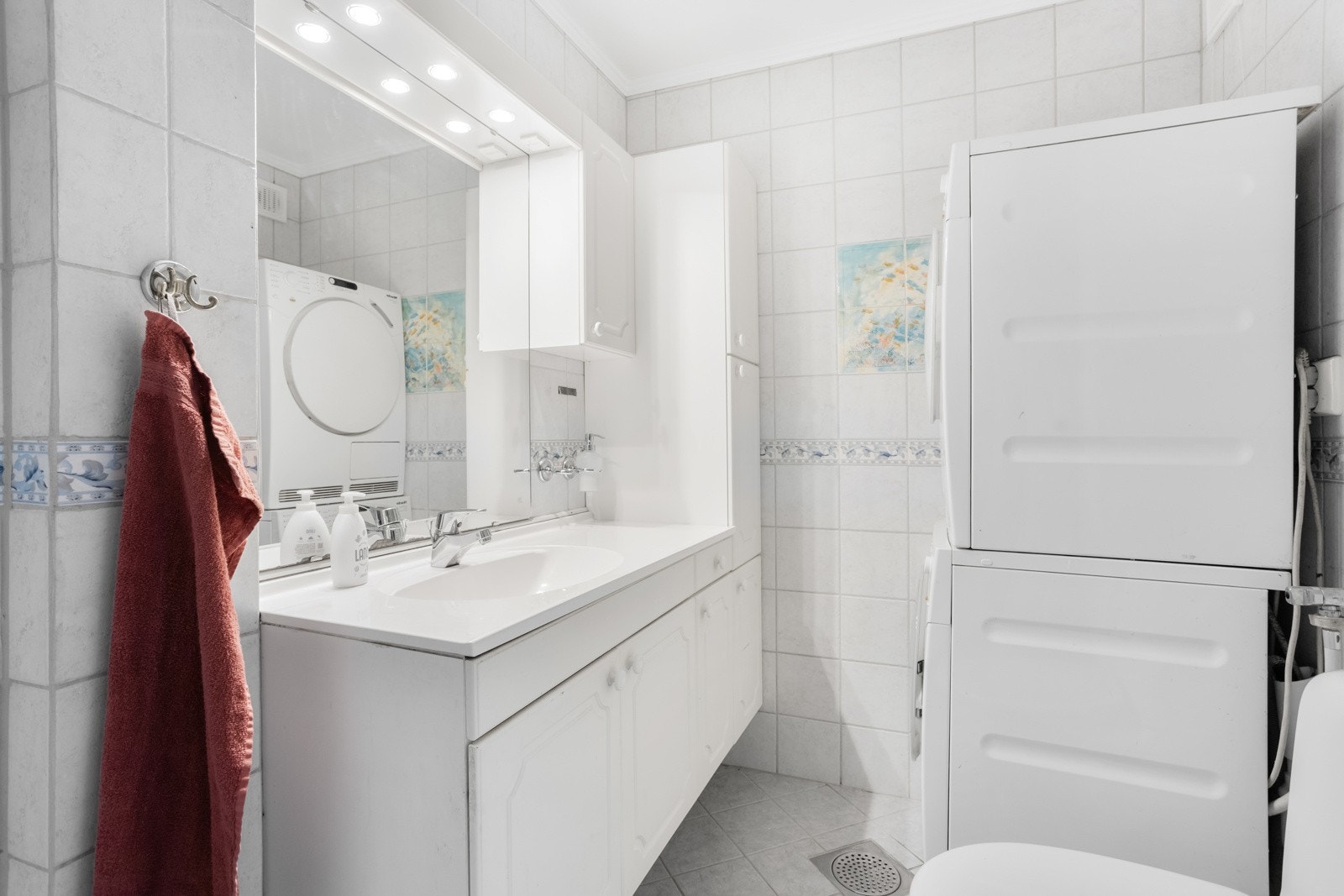 Her har du et lyst og fint bad med fliser på gulv med varmekabler, flislagte vegger og malt betong i innvendig tak. Galleribilde