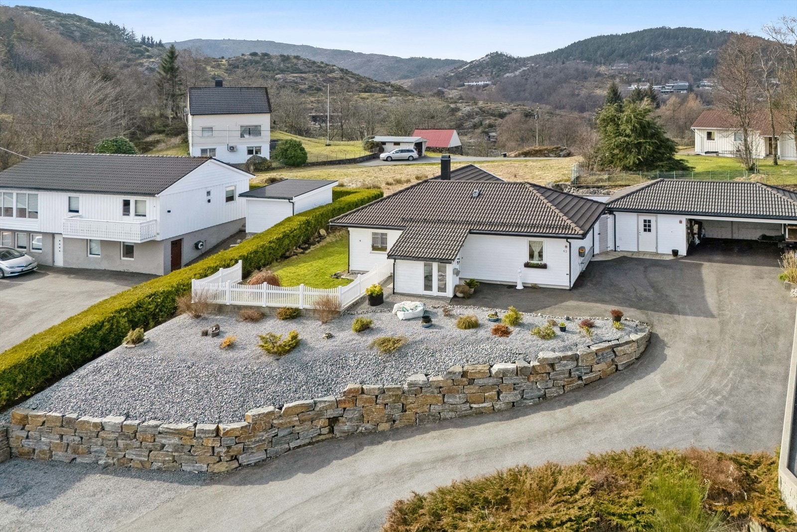 Tomten er pent opparbeidet med blant annet markterrasse, plen, asfaltert innkjørsel, mur og diverse beplantning. Galleribilde