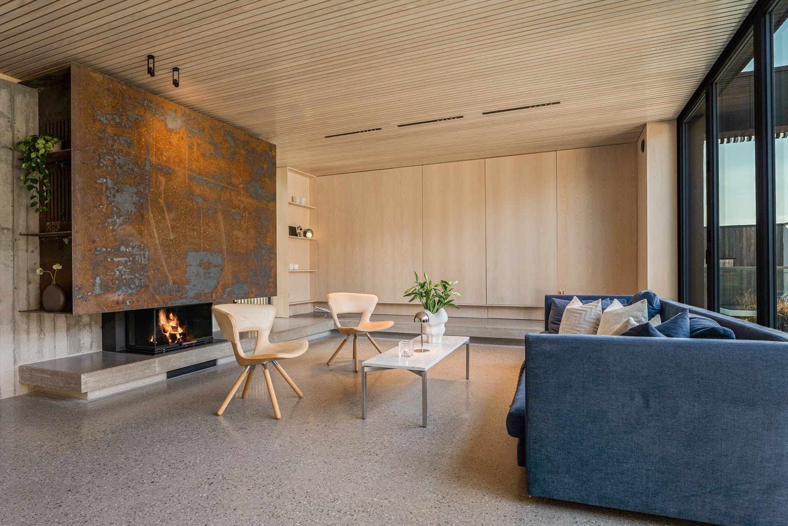 Plasstøpt betongbenk langs 2 av veggene i stuen- Legg merke til de plassbygde skapene i ask Galleribilde