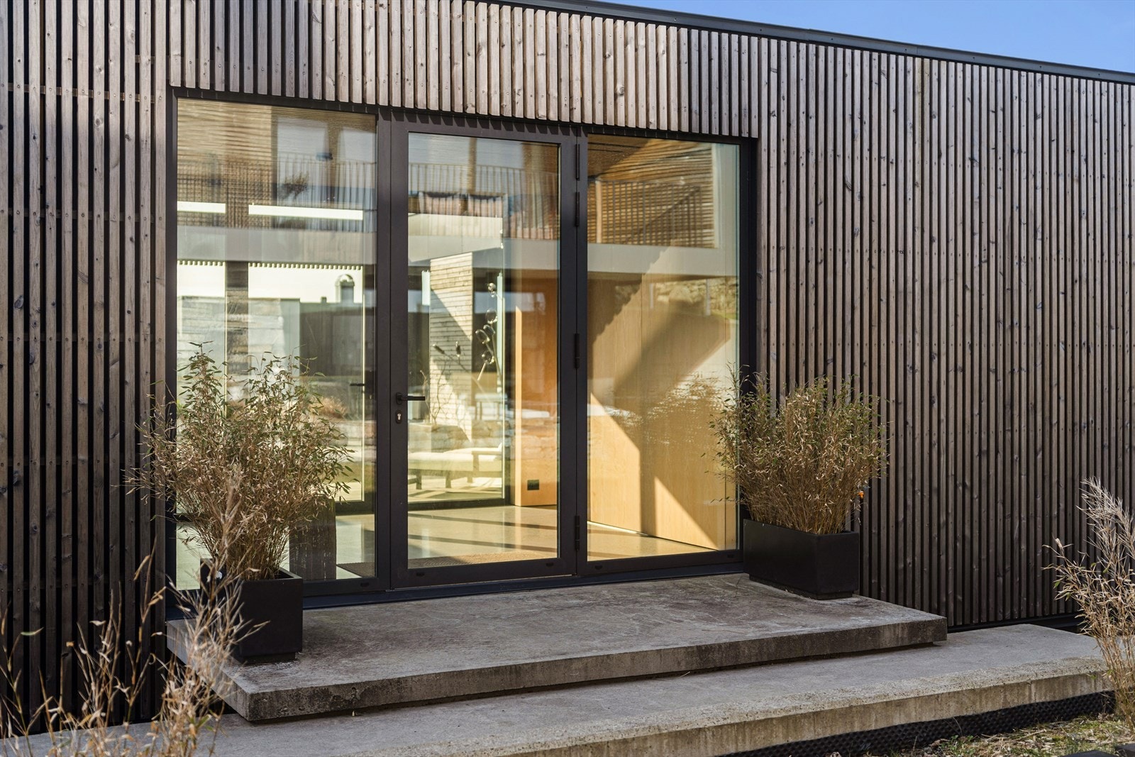 Lyst og trivelig inngangsparti med store glassdører fra Schuco. "Svevende" betongtrinn Galleribilde