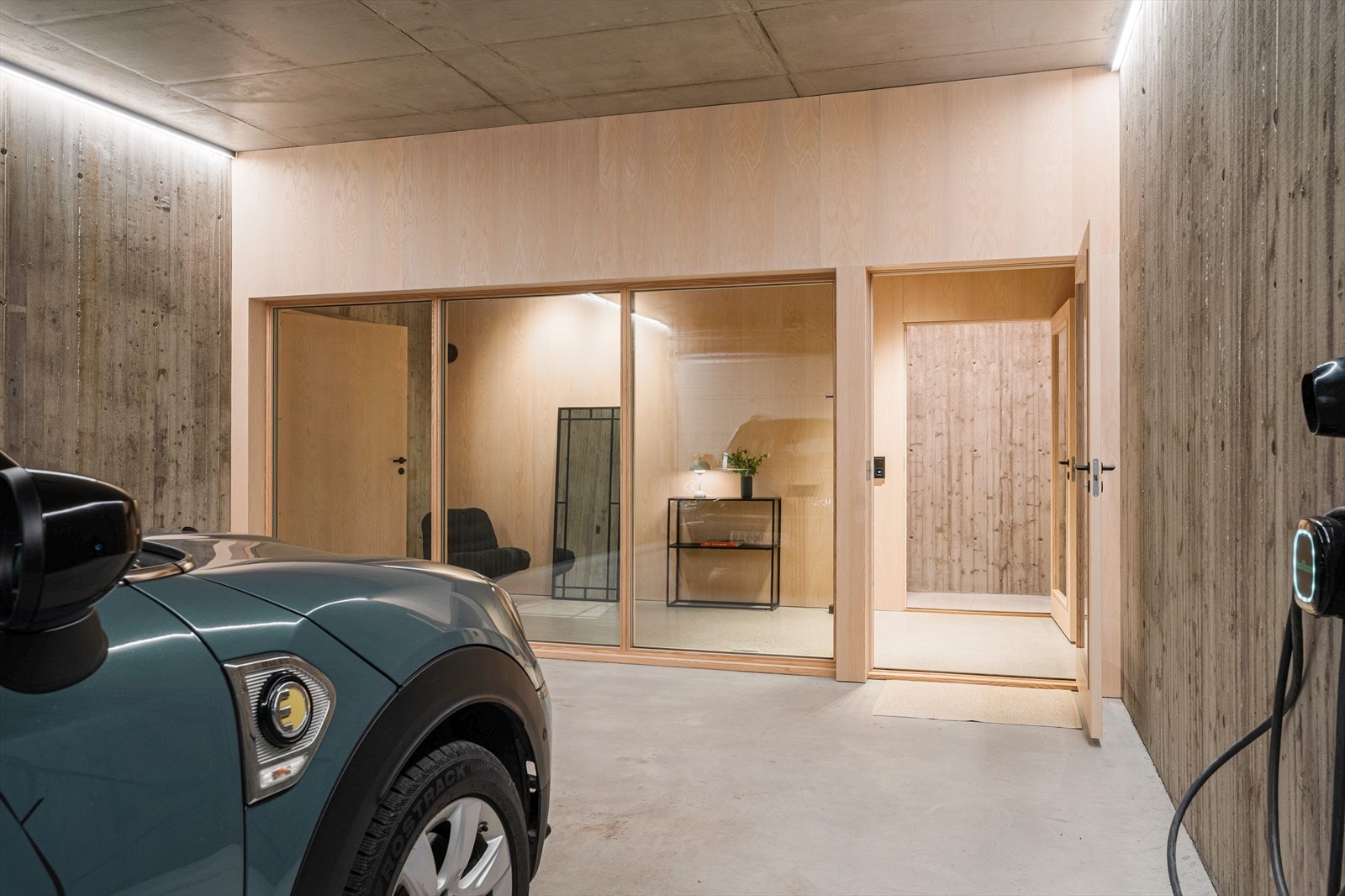 Garasjen har god belysning og har et røft utseende med bordforskalte betongvegger og tak i betong Galleribilde