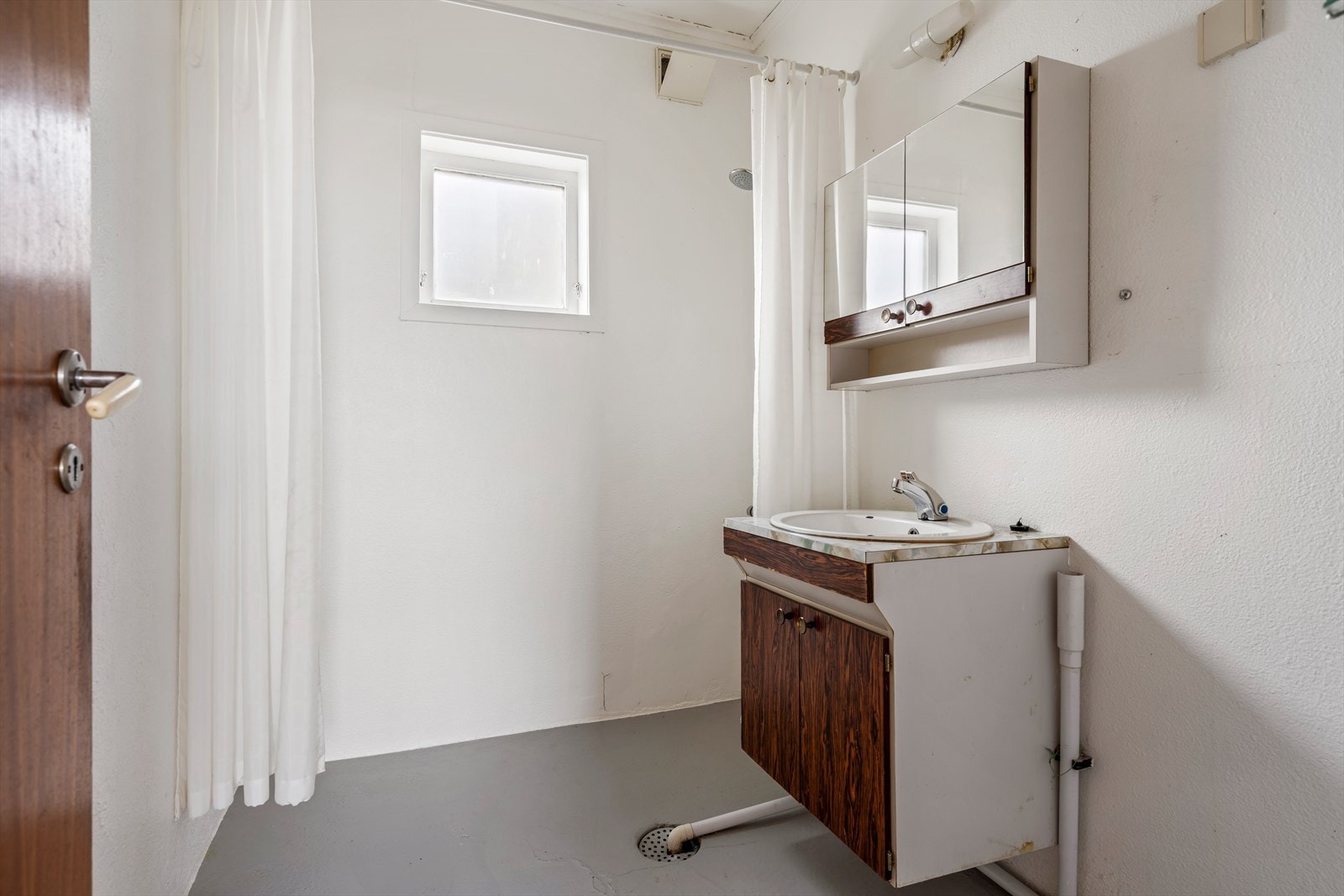 Eldre bad med dusj, baderomsinnredning og opplegg for vaskemaskin Galleribilde