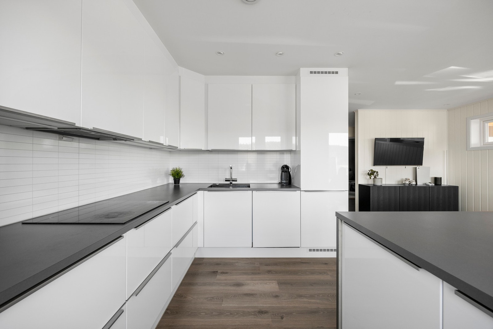 Det er godt med benk- og oppbevaringsplass. Kjøkkensonen er godt opplyst av downlights. Galleribilde