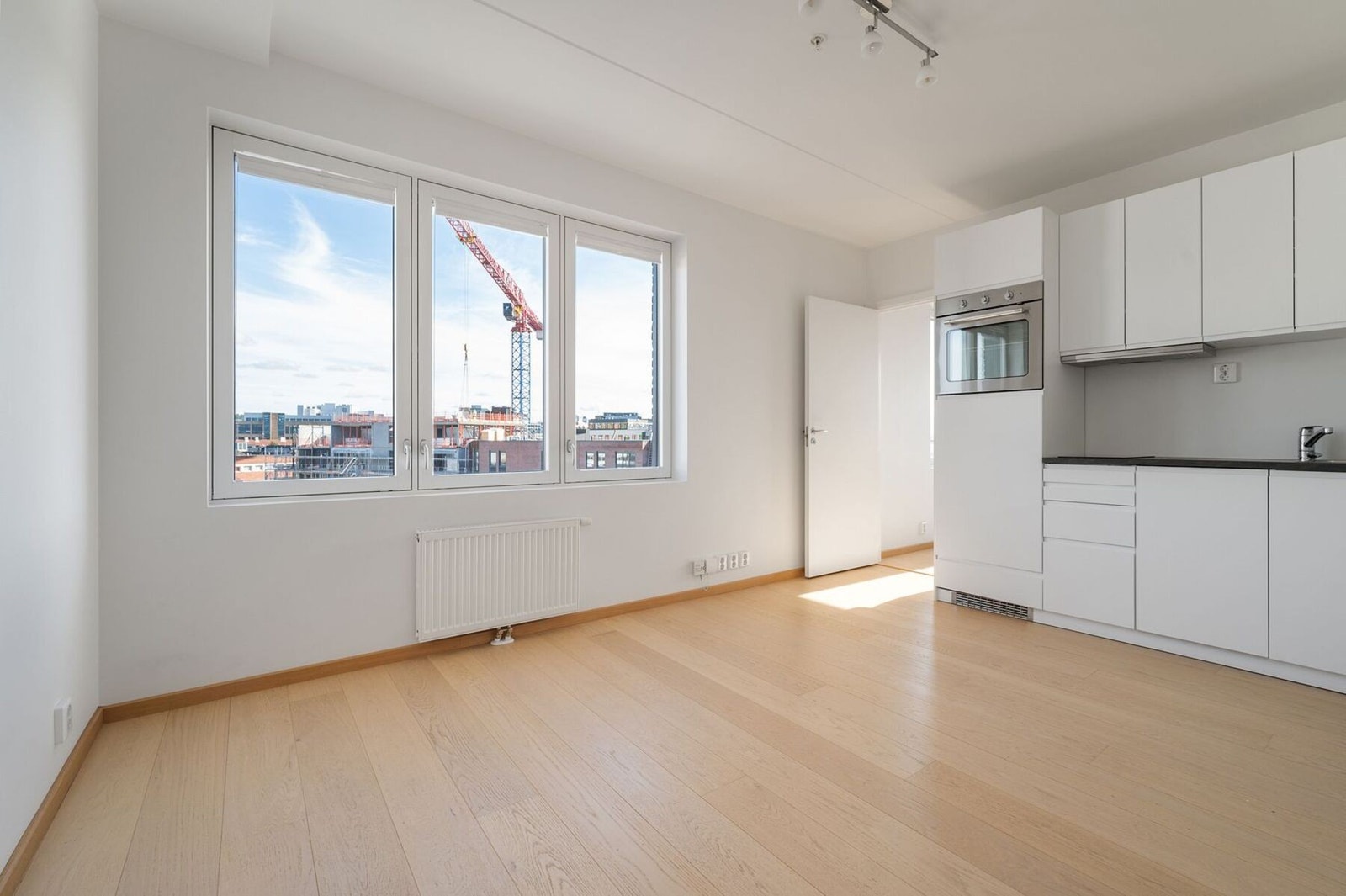 Hybel - Lys og romslig stue med store vinduer og plass til både sofagruppe og spisebord. Galleribilde