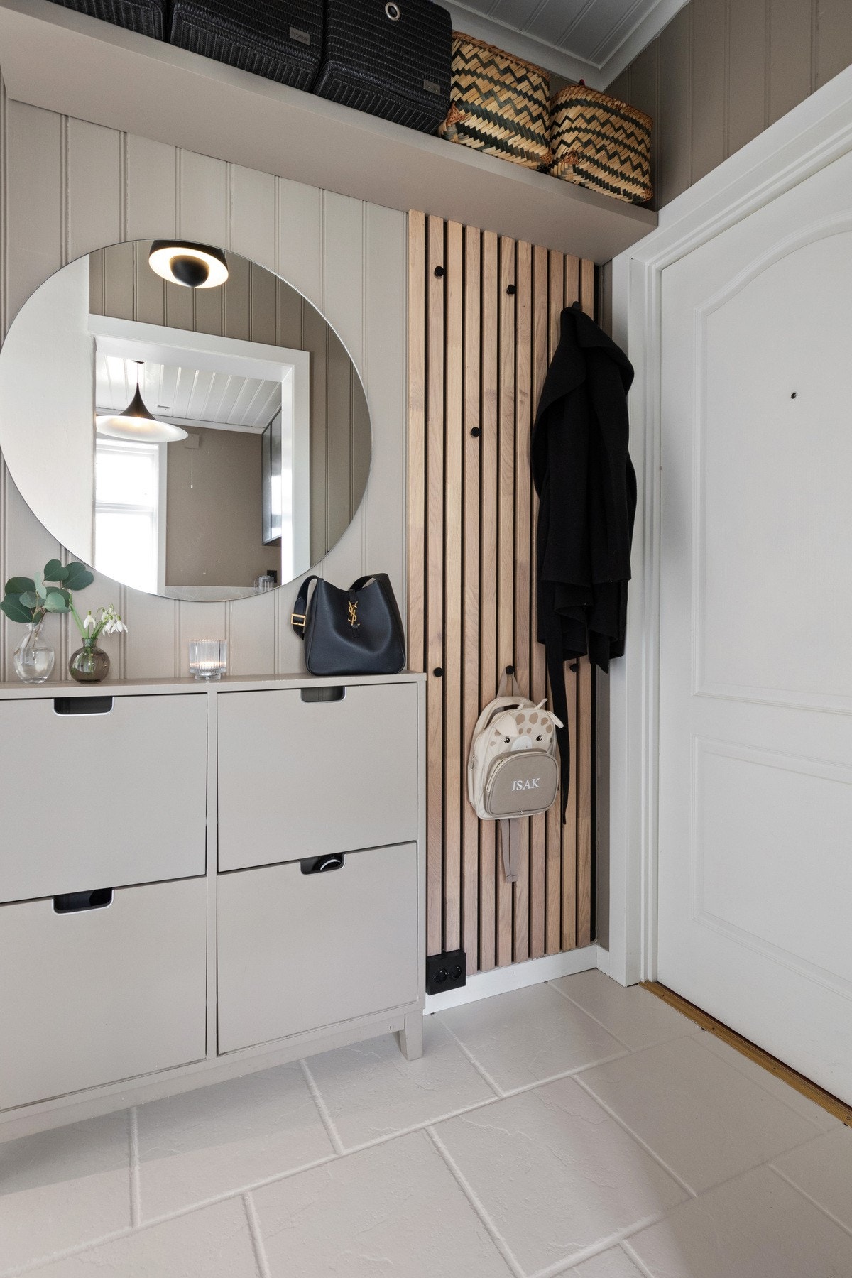 En porttelefon er montert ved inngangsdøren, og under en hylle har gangen spilevegg med knagger for klesoppheng. Galleribilde