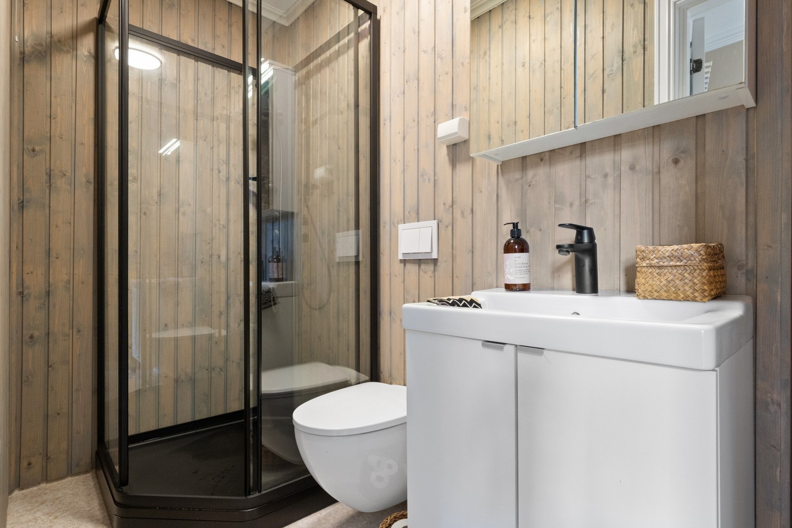 I 2024 ble badet oppgradert med et nytt dusjkabinett i sort utførelse. Vegghengt toalett er montert, og baderomsinnredningen består av et hvitt servantskap og et speilskap med belysning. Galleribilde