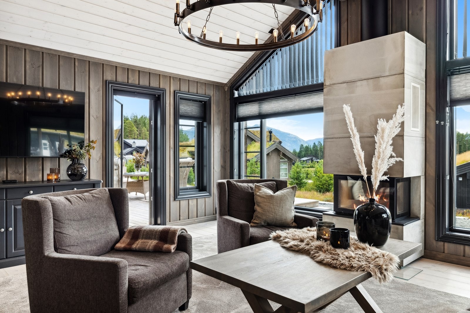 Hytta har en svært elegant stue med god takhøyde og luftig atmosfære. Sentralt i rommet er en flott peis med glassfronter. Fra stuen er det utgang til terrassen utenfor. Galleribilde