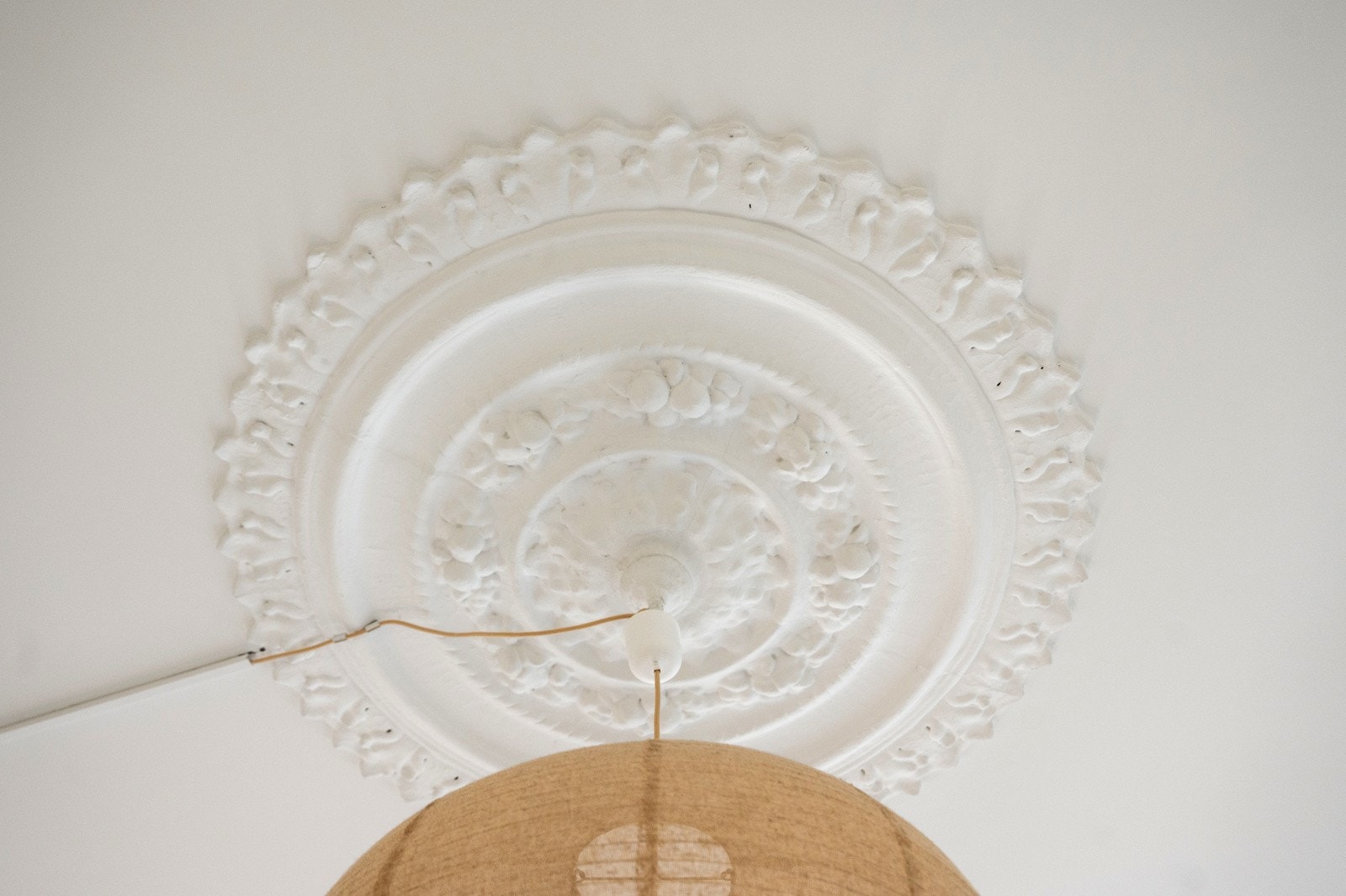 Veggene er utført i malt rabitzpuss og rommet preges av vakre originale elementer som stukkatur og en dekorativ takrosett som tilfører karakter Galleribilde