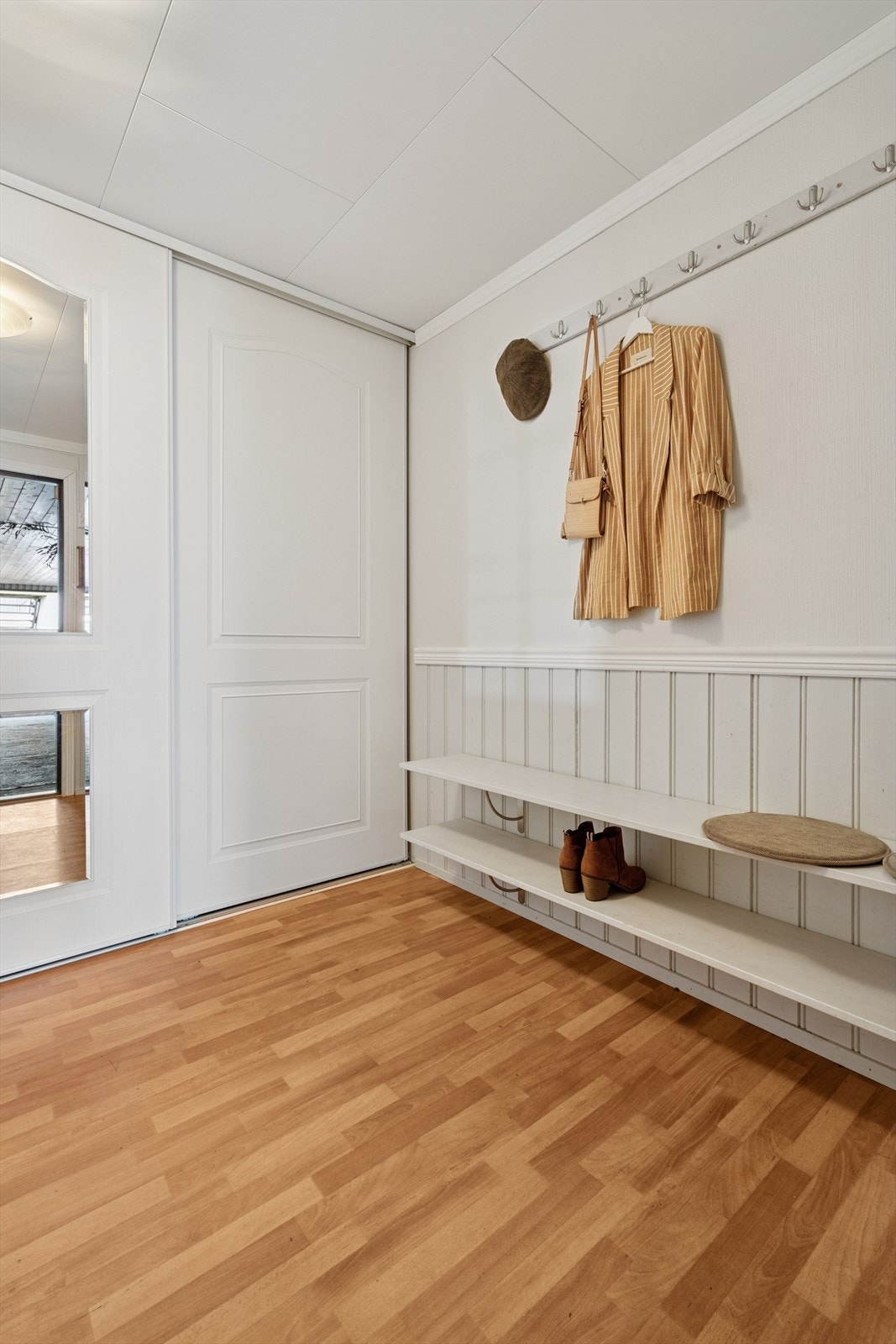 Praktisk entré med plass til å sette skoene og henge yttertøyet, både i og utenfor garderobeløsningen. Galleribilde