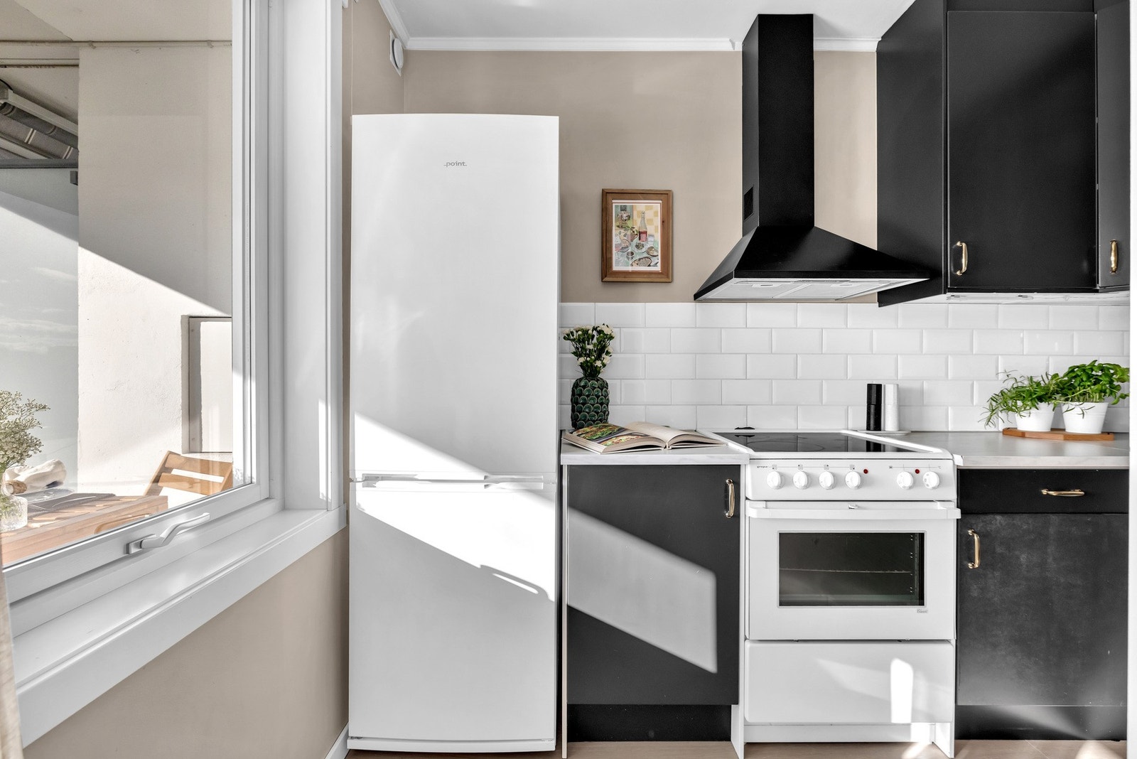 Sort kjøkkeninnredning med glatte fronter, benkeplate av laminat og nedsenket oppvaskkum med ett-greps armatur. Galleribilde