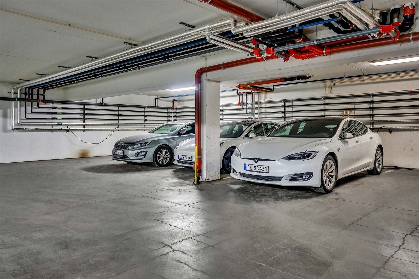 Leiligheten disponerer parkeringsplass nr. 49 i sameiets fellesareal. Det er montert Tesla-ladeboks på plassen. Galleribilde