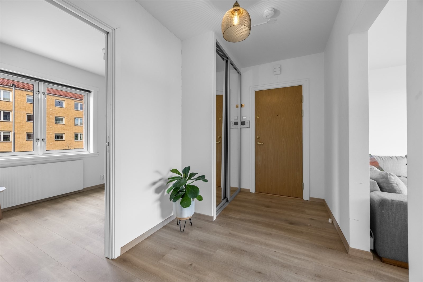 Leiligheten har en innbydende entré som gir et umiddelbart godt førsteinntrykk. Her er det rikelig med oppbevaringsplass i den romslige skyvedørsgarderoben med speilfronter, som både gir et stilrent uttrykk og forsterker romfølelsen. Galleribilde