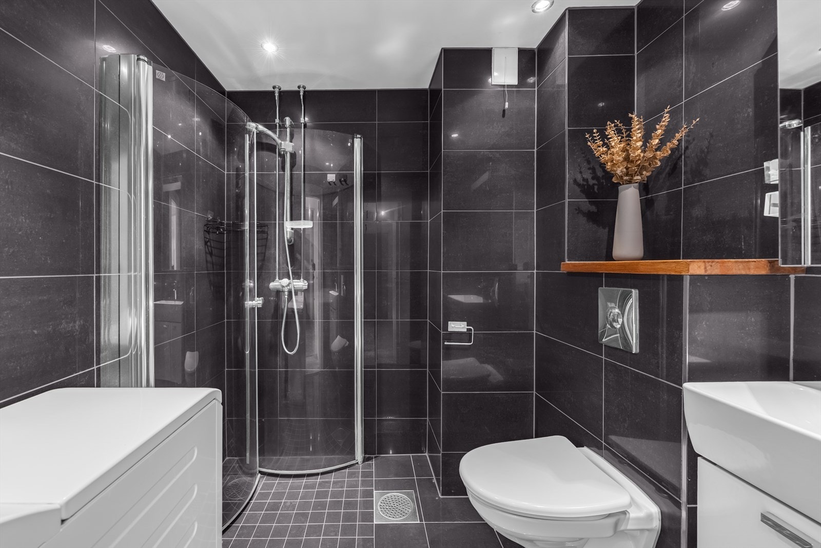 Pent flislagt baderom med innfelte downlights og elektrisk gulvvarme, oppusset i 2009 i regi av borettslaget. Galleribilde