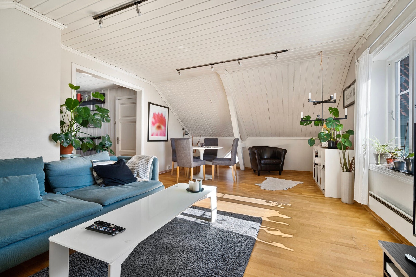 Stua er koselig, med parkettgulv, synlige trebjelker og vegger i en dus beigetone. Galleribilde