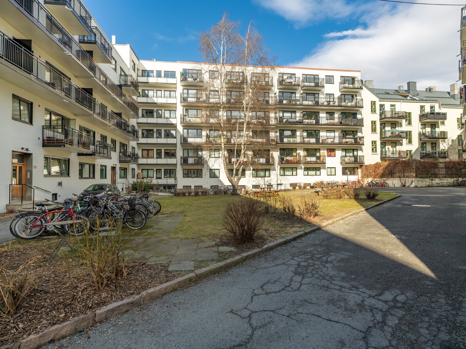 I den fine bakgården er det gressplen, trær, sittegrupper og hyggelig beplantning til glede for beboerne. Den deles med de omkringliggende blokkene. Galleribilde