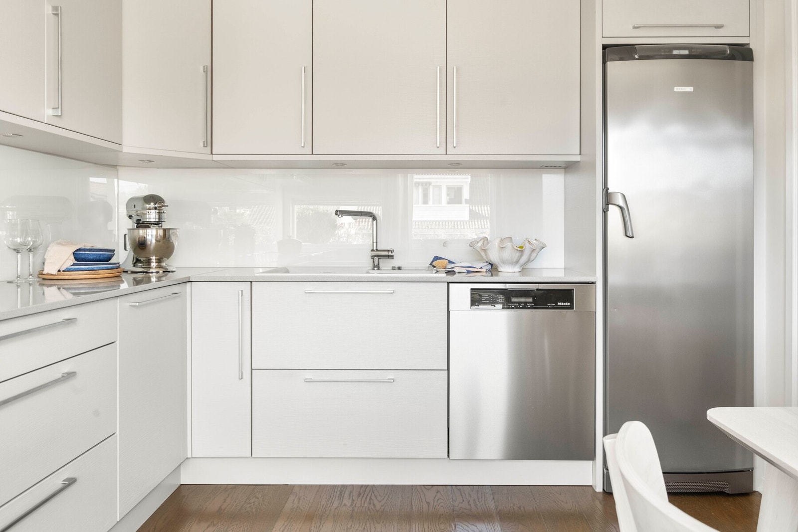 Frittstående hvitevarer bestående av komfyr med induksjonstopp, oppvaskmaskin og kjøleskap, medfølger salget. Galleribilde