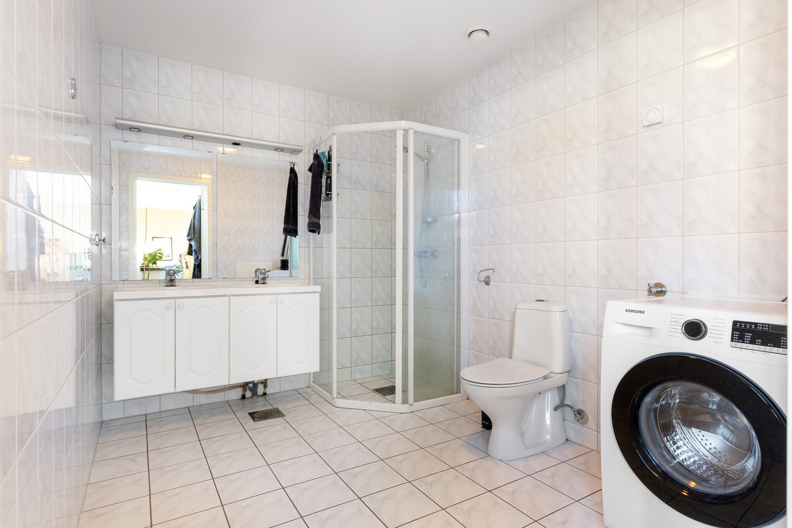 Badet har flislagte overflater på vegger og gulv. Opplegg til vaskemaskin Galleribilde