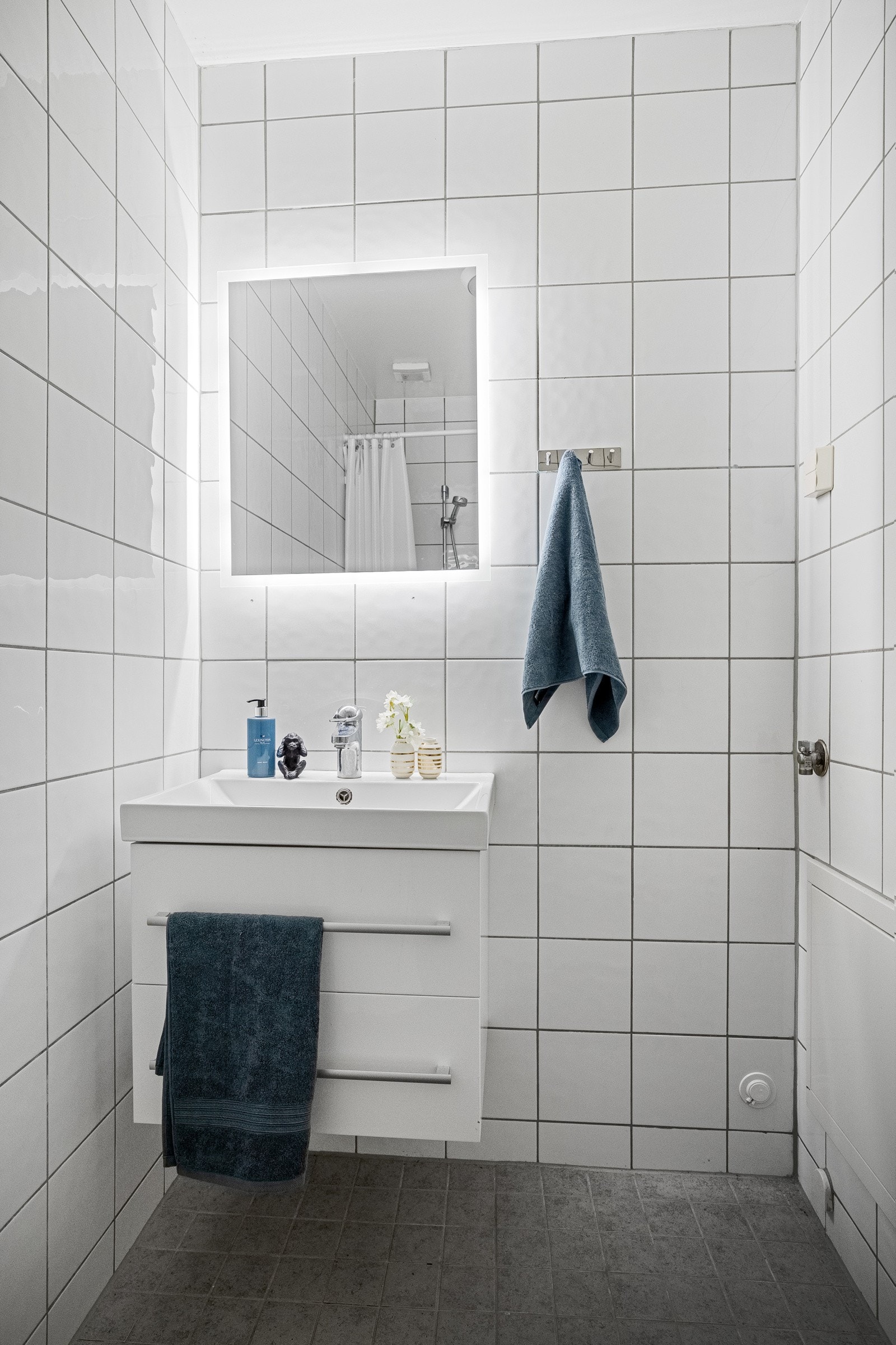 Flislagt bad med varmekabler i gulv. Servantseksjon med skuffer og speil med integrete lys. Galleribilde