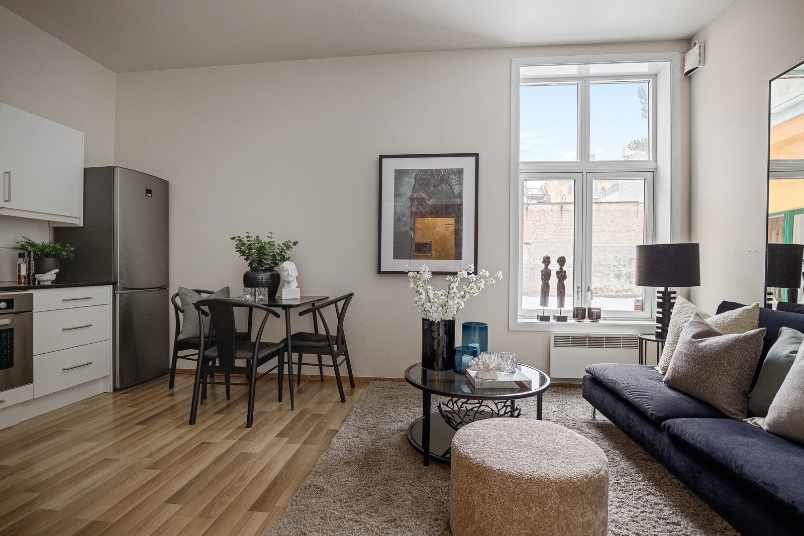 Gjennom inngangsdøren kommer du inn til en åpen stue- og kjøkkenløsning. Rommet har både god takhøyde og store vinduer. Galleribilde