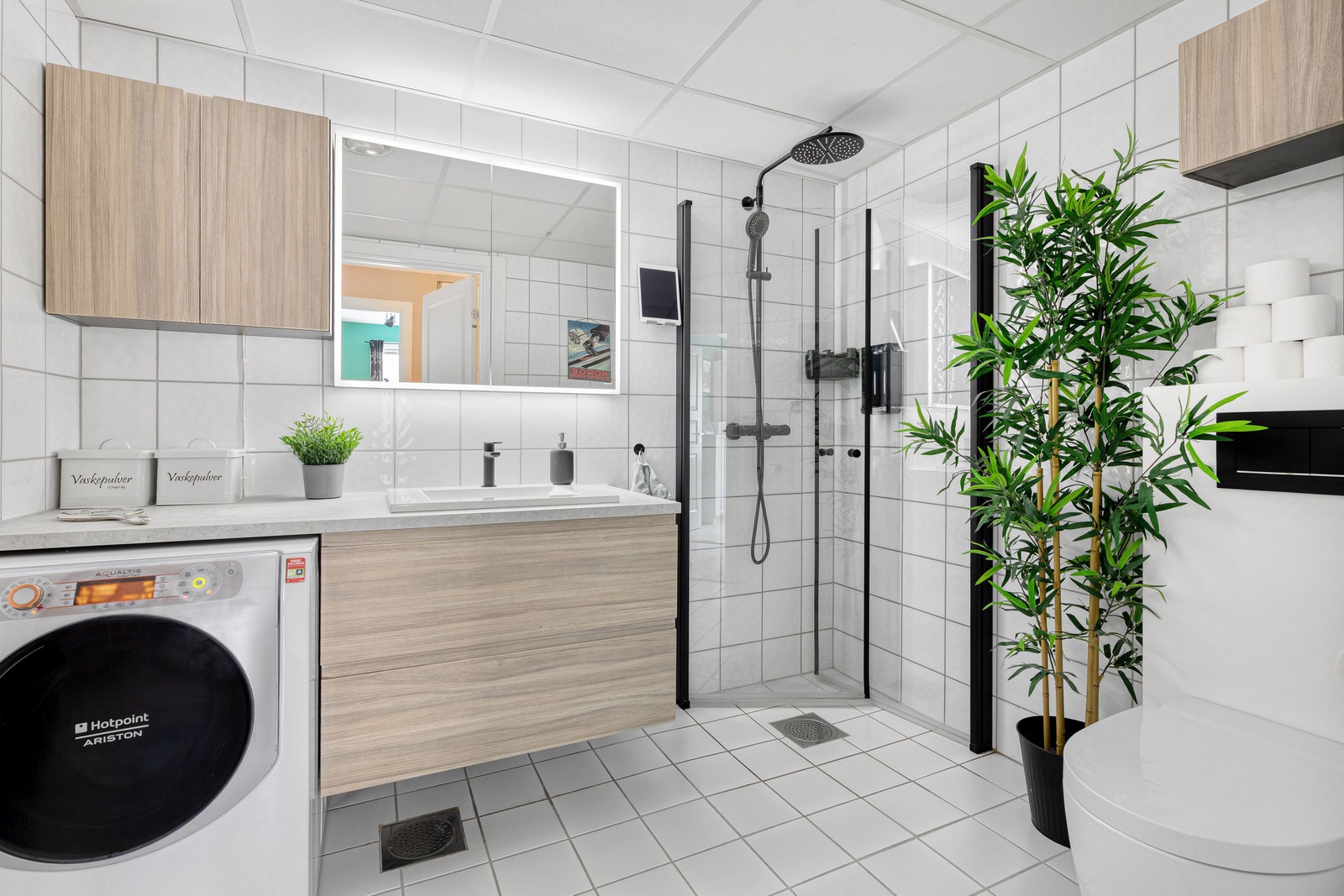 Flislagt bad med varmekabler. Badet har spyletoalett og høytalere bak speilet som kan styres fra iPad på veggen Galleribilde
