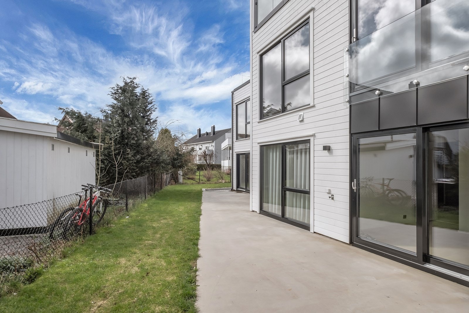 Uteplass med støpt platting og en liten hageflekk Galleribilde