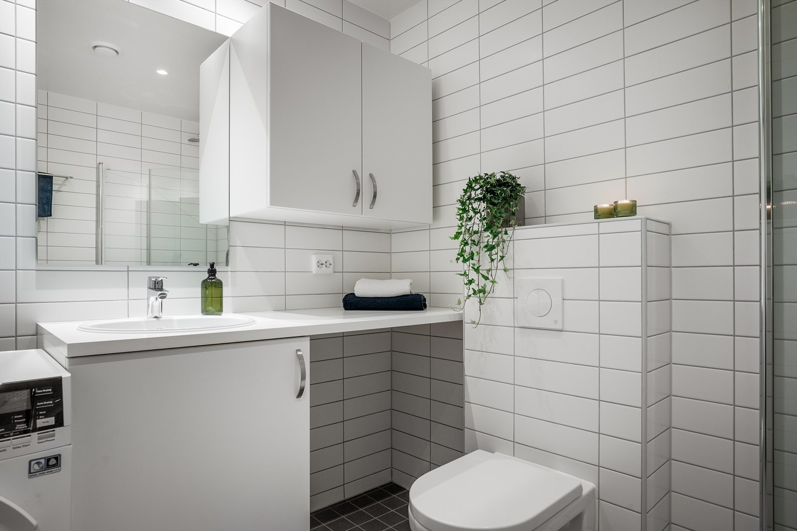 Det er opplegg for vaskemaskin, samt overskap med to skapdører for ekstra oppbevaring. Galleribilde