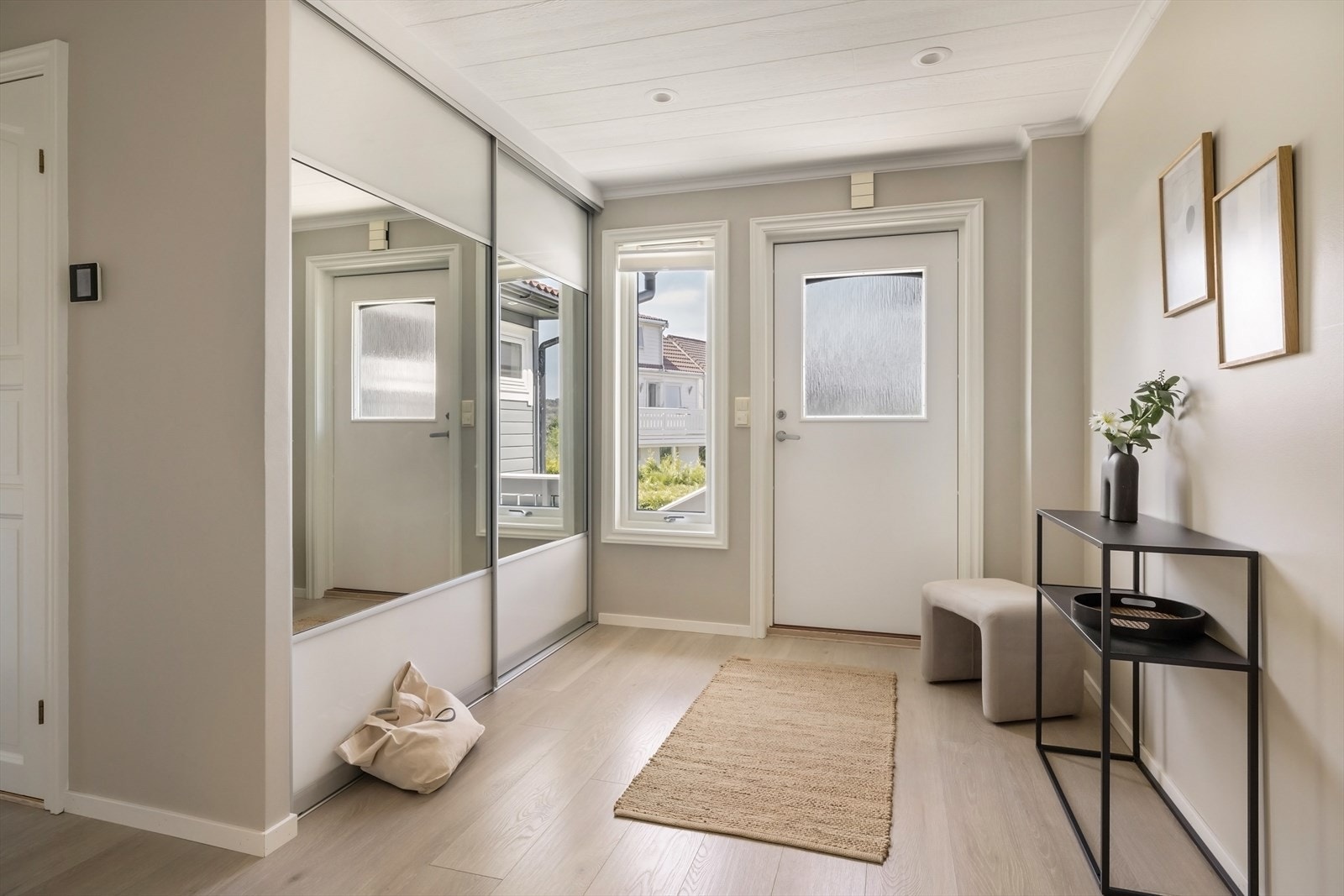 Lys og luftig entrè med god plass til sko og yttertøy i skyvedørsgarderobe. Galleribilde