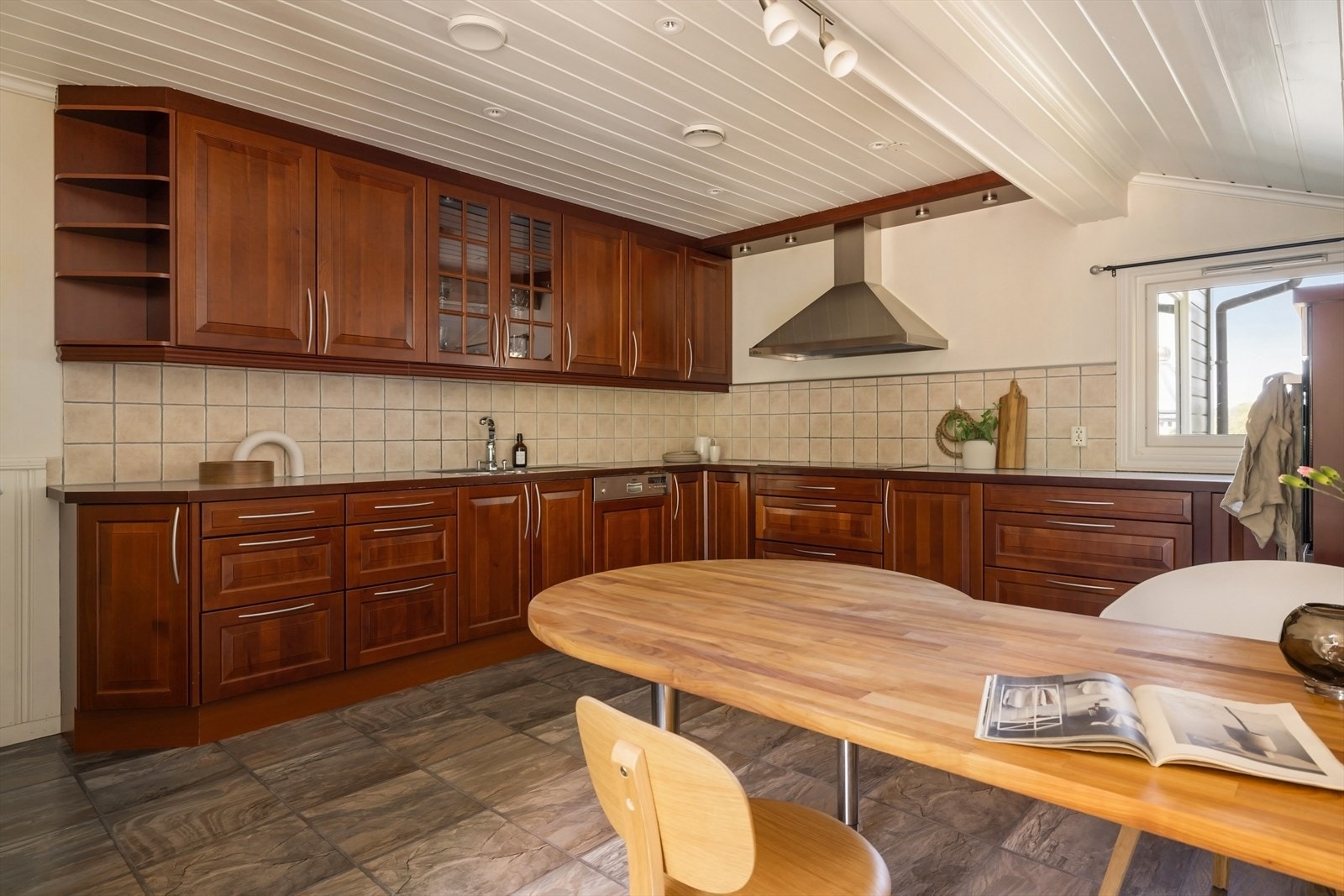 Kjøkkenet består av en klassisk innredning fra HTH med profilerte fronter, ett overskap med glassfront og benkeplate av laminat hvor det er benyttet fliser på veggen over. Galleribilde