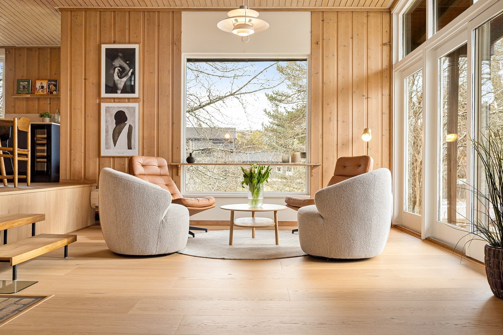 Stuen ligger på det nedre nivået av rommet. Nivåforskjellen skaper en effektiv, men subtil inndeling av rommet i naturlige soner. Området ved utgangsdøren til hagen minner nesten om en vinterhage, perfekt for en sittegruppe og kaffebord. Galleribilde