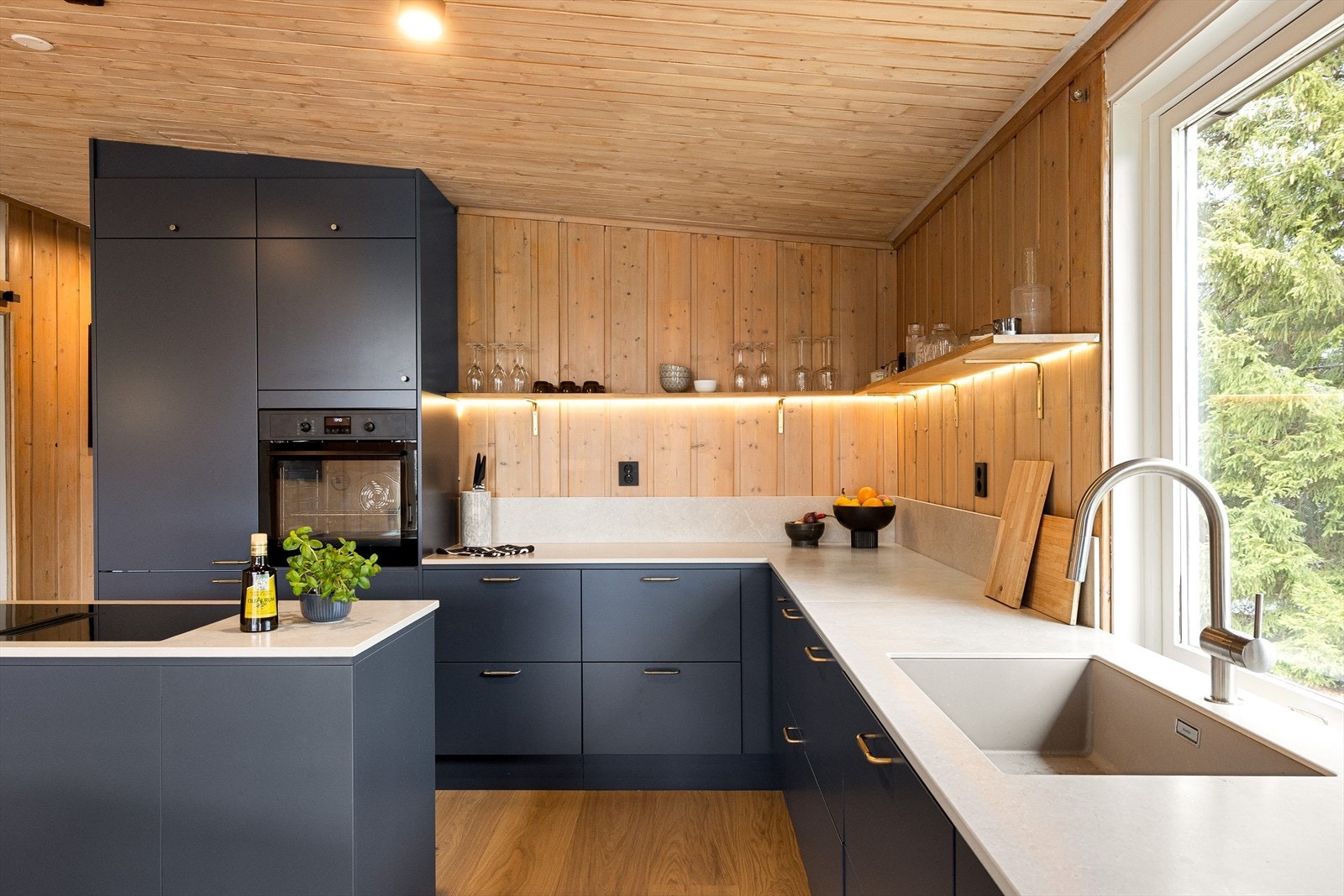 Det er integrert kjøleskap, fryser og nedfelt vask. Steketoppen er integrert i kjøkkenøyen sammen med avtrekksviften. Galleribilde