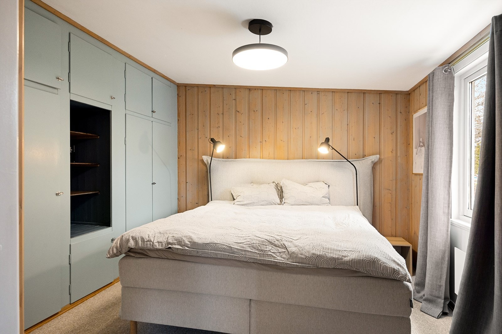Hovedsoverommet har god plass til dobbeltseng og tilhørende nattbord. Gulvet er dekket av teppe for ekstra komfort. Rommet har et stort plassbygget skap i en farge som skaper en fin kontrast til resten av interiøret. Galleribilde
