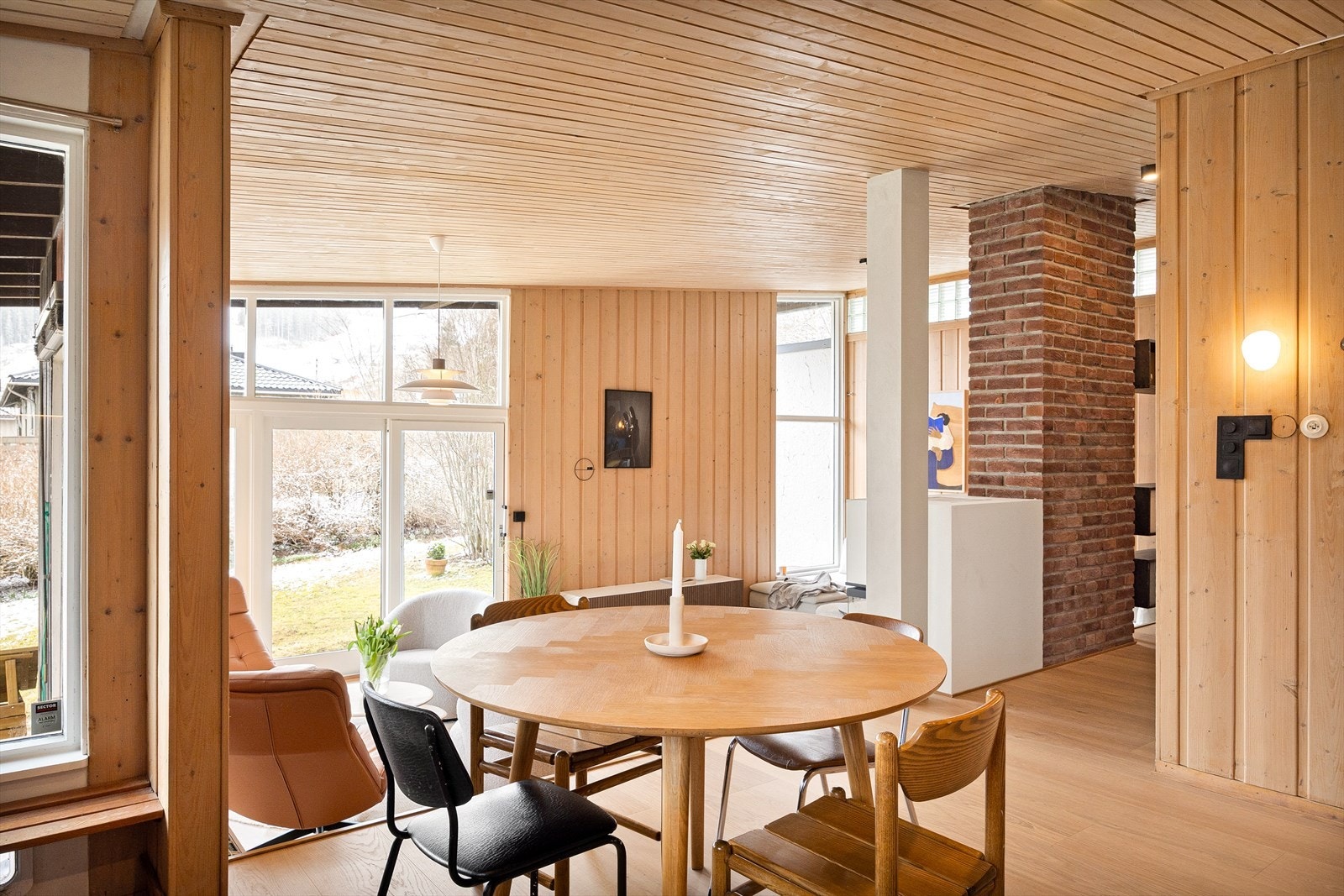 Nivåforskjellen fungerer ikke bare som en visuell og funksjonell skillelinje, men bidrar også til en fantastisk lysføring i rommet. Ved å la lyset strømme fritt fra stuen og opp i kjøkkenet, skapes en følelse av rommelighet og sammenheng mellom sonene. Galleribilde