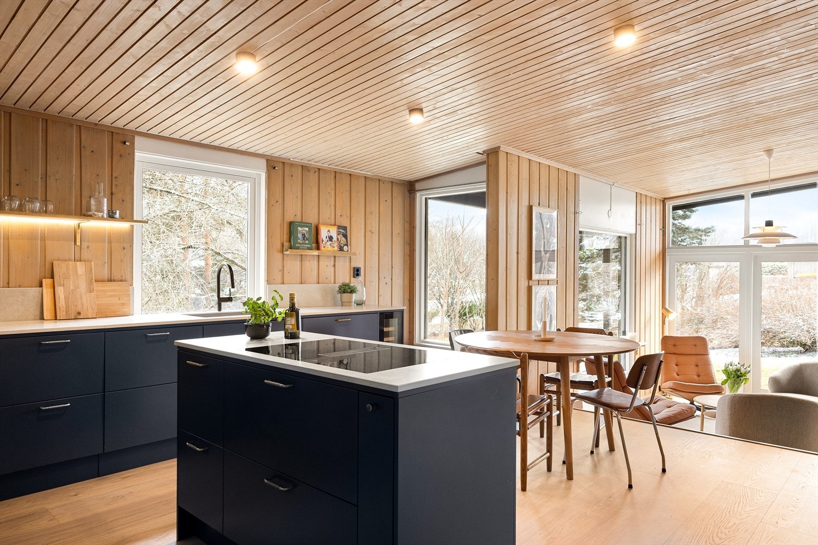 Det er rikelig med benkeplass, og steketoppen samt avtrekksviften er integrert i kjøkkenøyen. Dette designvalget understreker ønsket om at rommet skal fungere som en sosial sone, perfekt for middagsselskaper og samvær. Galleribilde