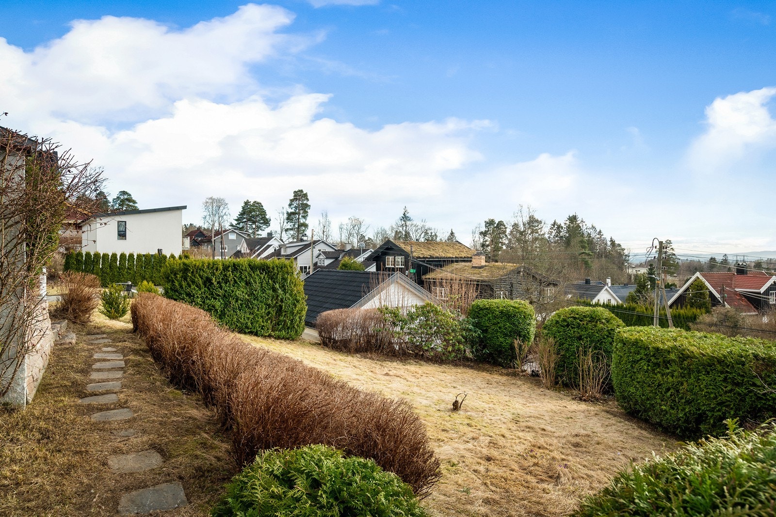 Eiendommen har en frodig og solrik tomt. Hagen strekker seg rundt hele boligen og egner seg utmerket til lek, soling og hyggelige sammenkomster Galleribilde