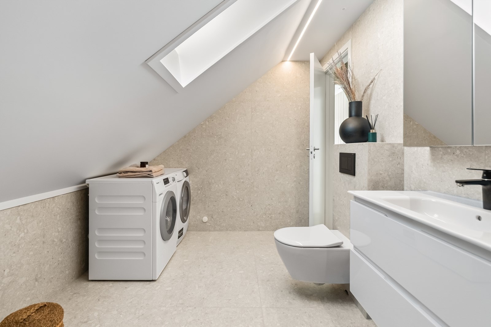 Opplegg for vaskemaskin er etablert, og badet har varmekabler og vegghengt toalett. Galleribilde