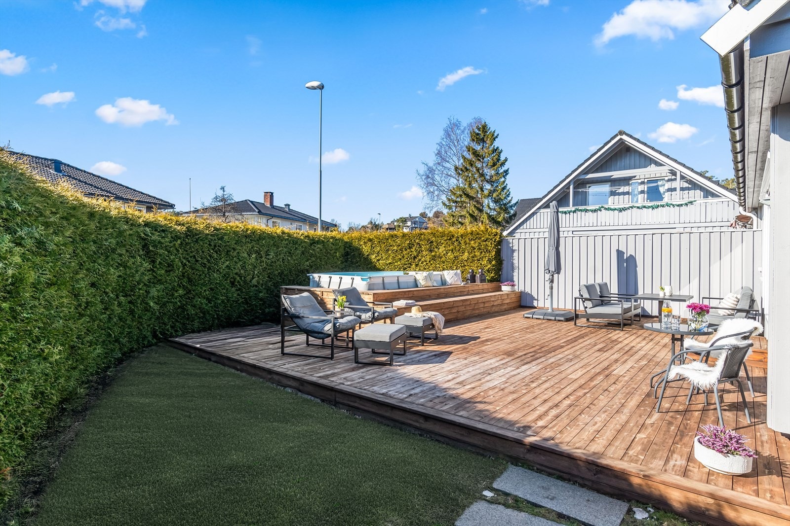 Tomten er opparbeidet med en velstelt hekk i buet utforming. Hagen er lettstelt, og det er plass til en trampoline for de yngste i familien. Galleribilde