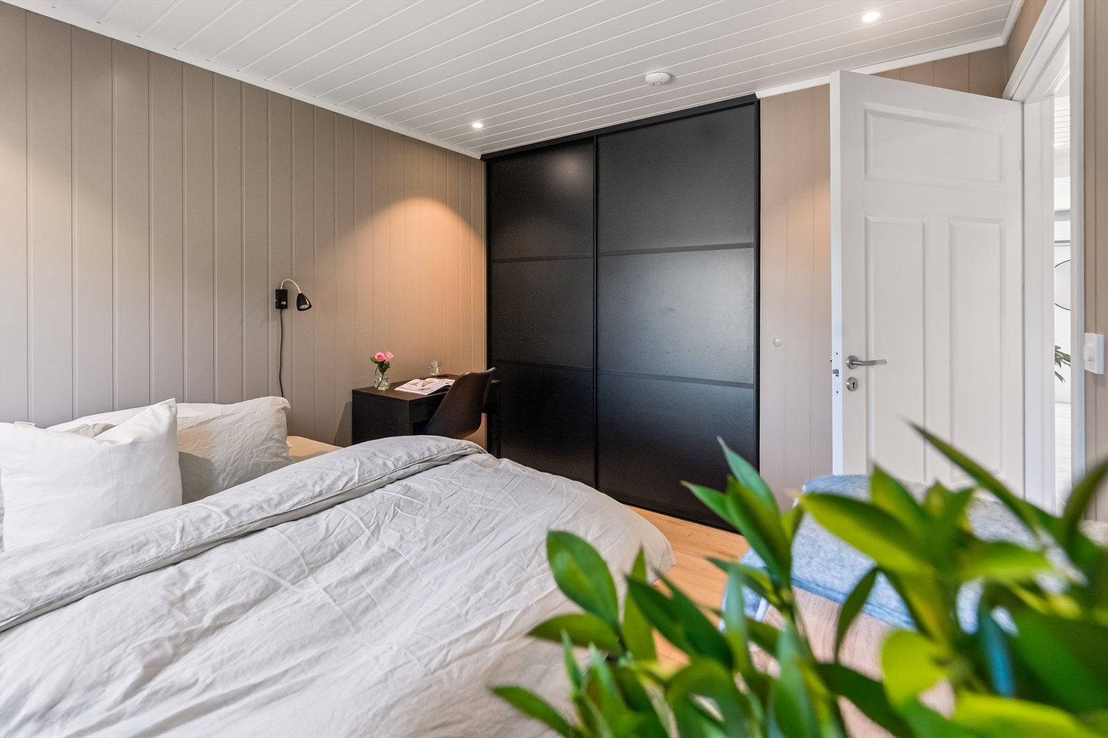 Det er plass til dobbeltseng, og rommet har mye oppbevaring i en stor og plassbygd skyvedørsgarderobe med sorte fronter. Galleribilde