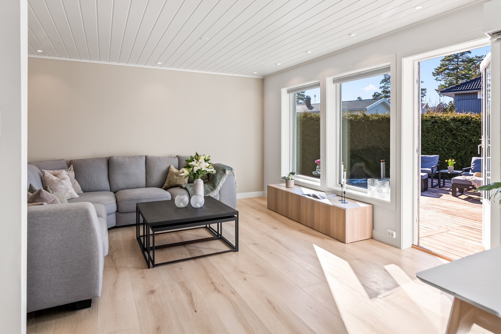 Dagslyset i stuen suppleres ypperlig av downlights rundt store deler av himlingen, og 1-stavs laminat er lagt på gulvet og den ene veggen for et helhetlig uttrykk. Galleribilde