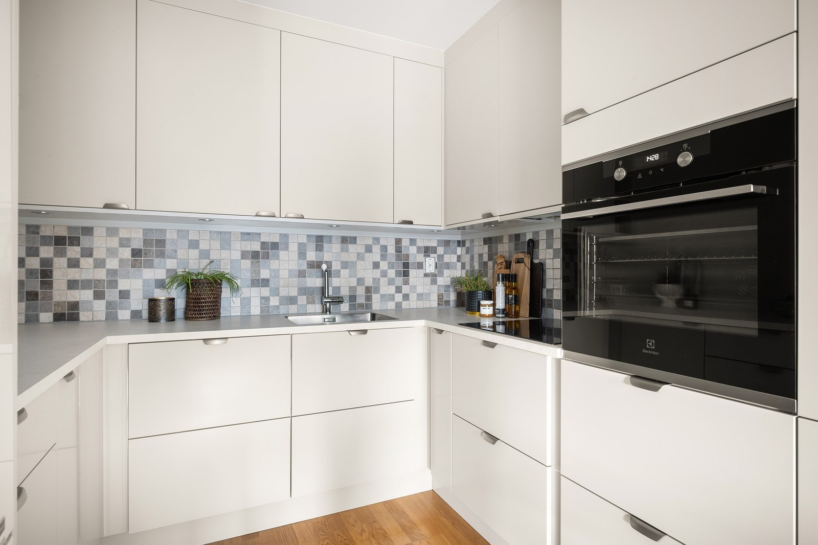 Kjøkkeninnredningen er av glatte fronter og laminatbenkeplate nedfeldt oppvaskkum. Galleribilde