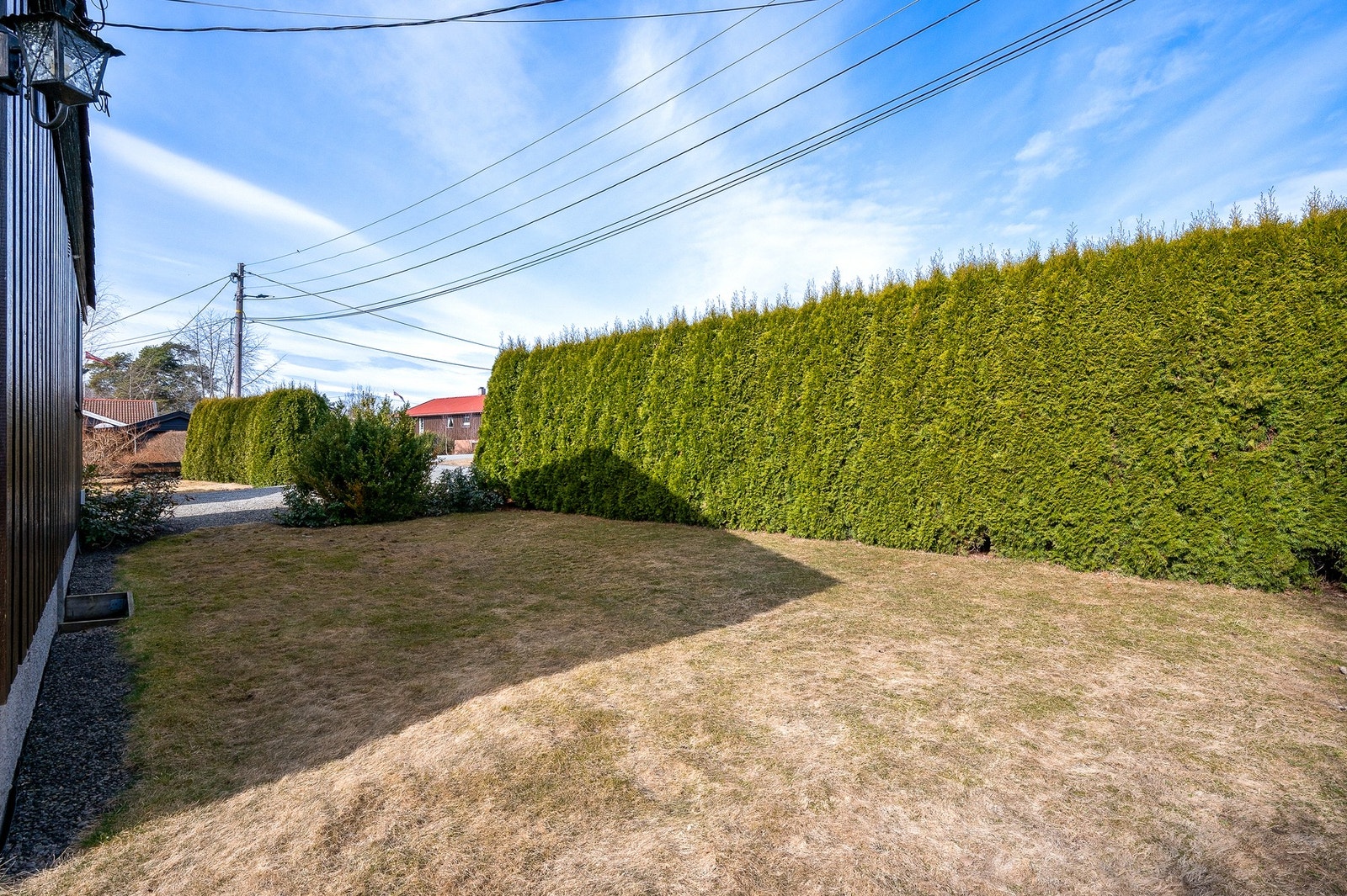Den tette, grønne hekken rundt boligen skaper en naturlig skjerm, som gir en følelse av å være i sin egen, lille verden. Galleribilde