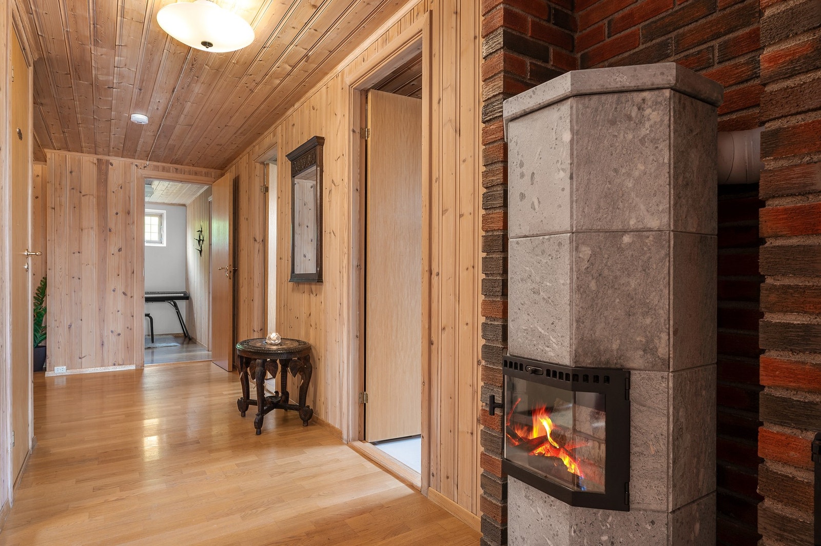 Gangen i kjeller er utstyrt med peisovn med glassdør. Galleribilde