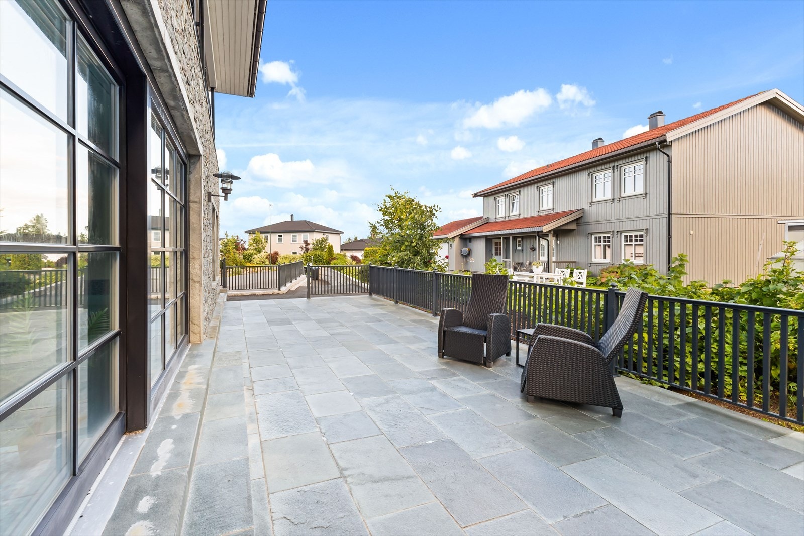 Bassengområdet har skyvedører som kan åpnes helt mot uteplassen på 48 m² med støpt dekke og skiferstein Galleribilde